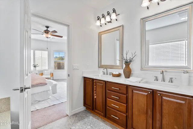 a en suite bathroom with double vanity sinks a mirror and a window