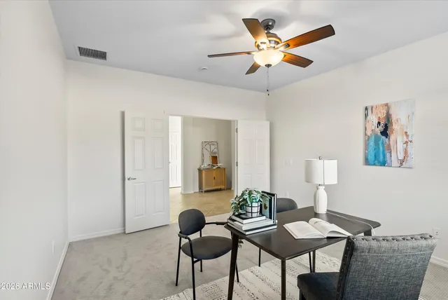 a work room with furniture and a ceiling fan