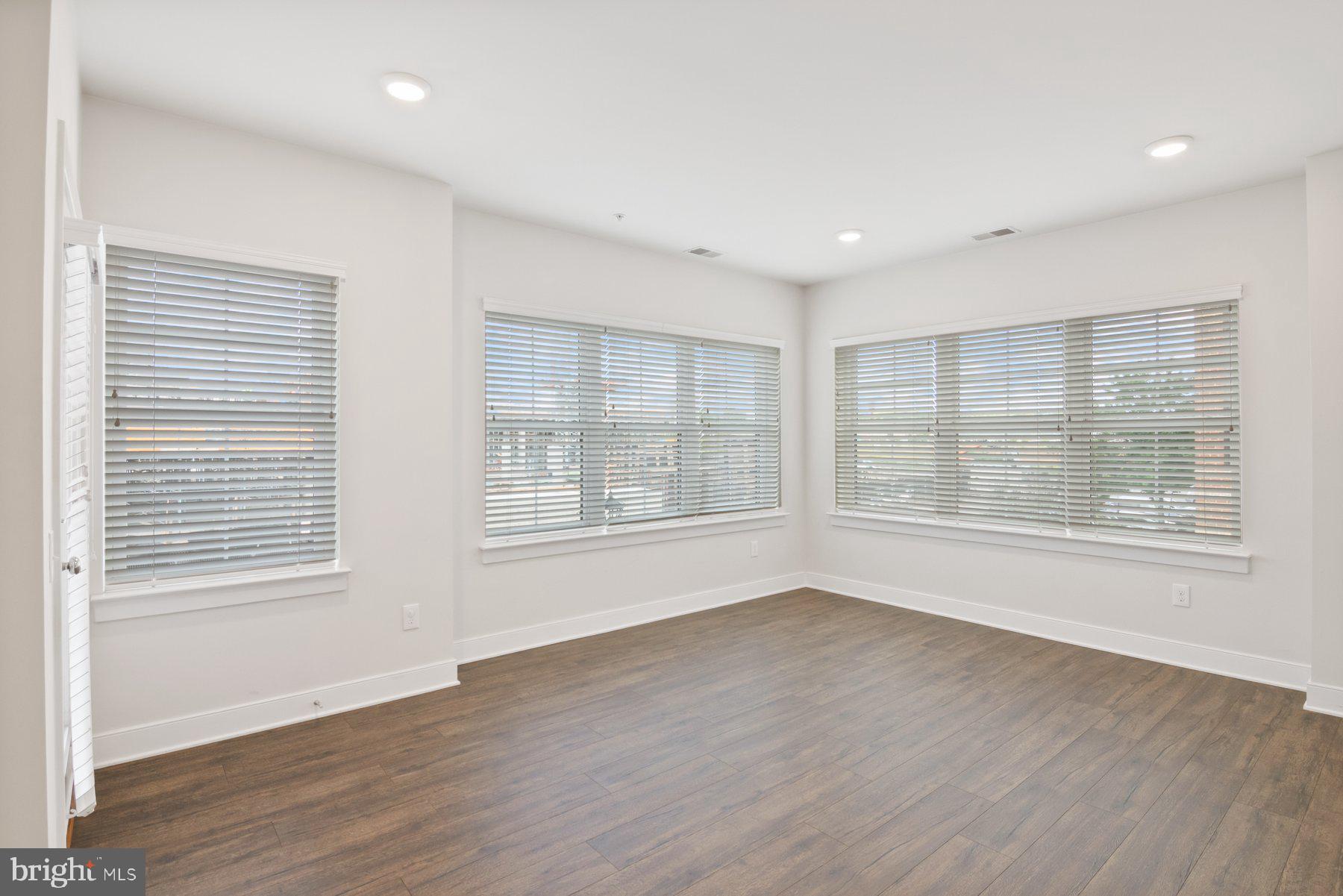 2907 Bleeker Street, Unit 204 Fairfax, VA 22031 - Photo 3 of 20 a view of an empty room with wooden floor and a window