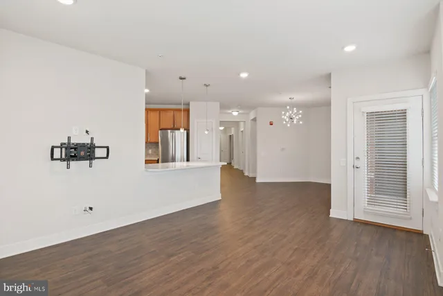 a kitchen with a refrigerator a sink and wooden floor