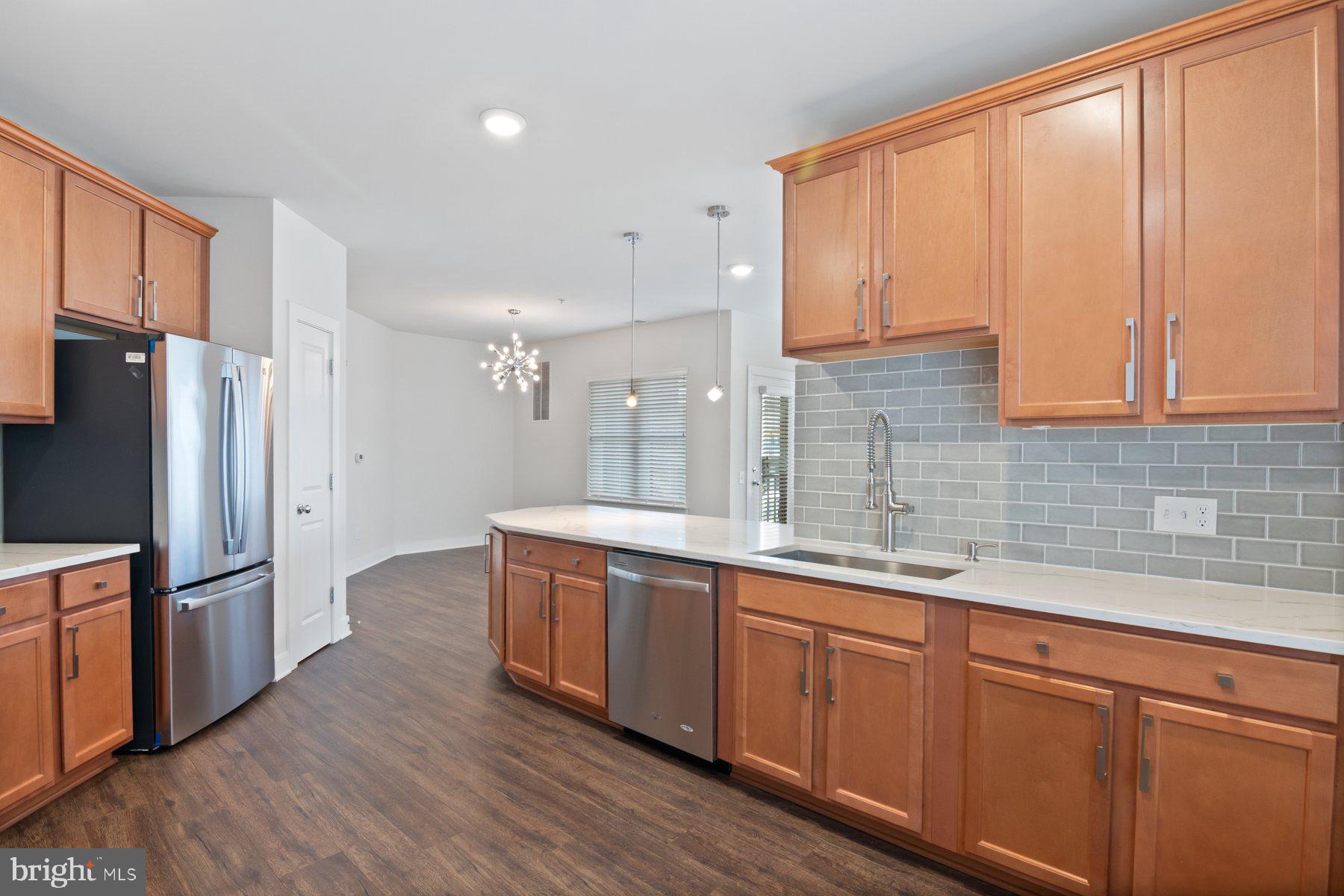 2907 Bleeker Street, Unit 204 Fairfax, VA 22031 - Photo 8 of 20 a large kitchen with stainless steel appliances granite countertop a refrigerator a sink dishwasher and wooden cabinets with wooden floor