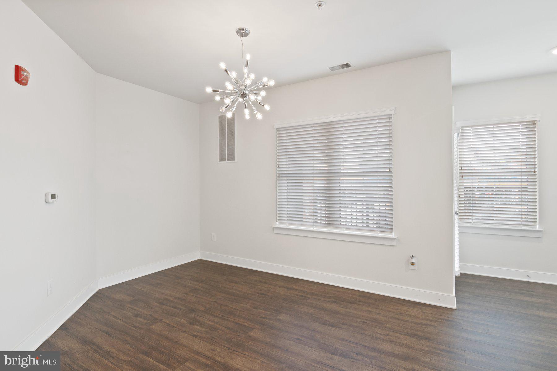 2907 Bleeker Street, Unit 204 Fairfax, VA 22031 - Photo 9 of 20 a view of an empty room with wooden floor and a window
