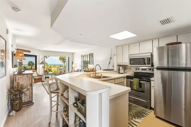 a kitchen with stainless steel appliances kitchen island granite countertop a stove top oven a sink and cabinets