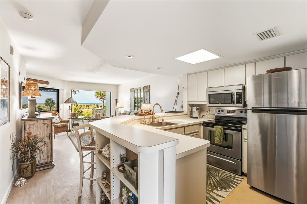 5000 Gasparilla Road, Unit BC103 Boca Grande, FL 33921 - Photo 6 of 36 a kitchen with a stove a refrigerator and a dining table