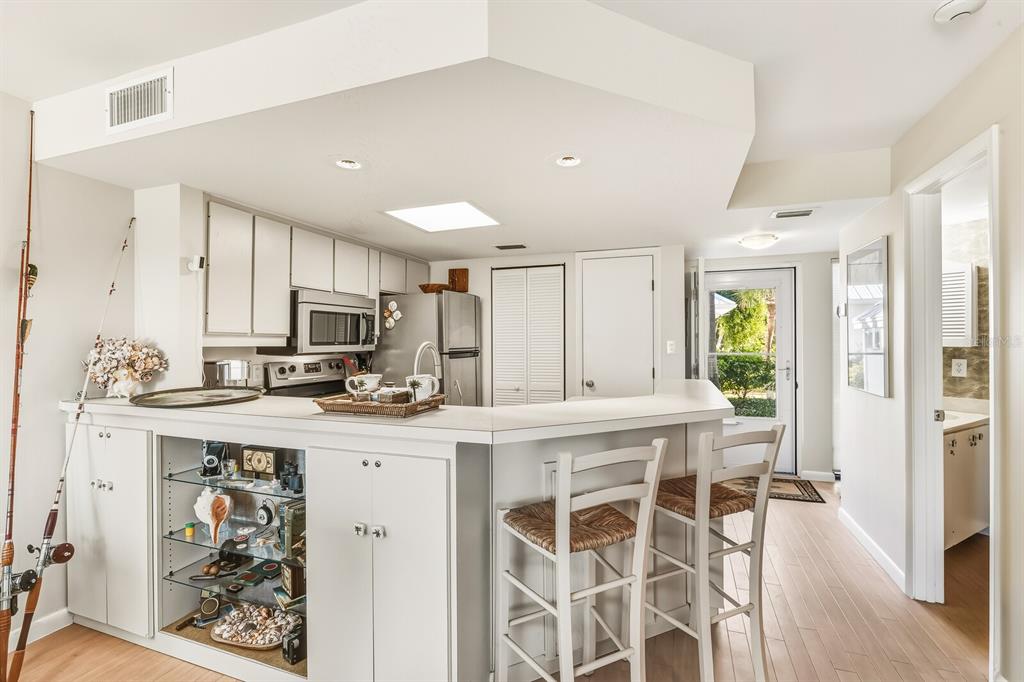 5000 Gasparilla Road, Unit BC103 Boca Grande, FL 33921 - Photo 7 of 36 a kitchen with stainless steel appliances kitchen island granite countertop a stove top oven a sink and cabinets