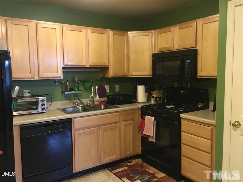 3020 Barrymore Street, Unit 103 Raleigh, NC 27603 - Photo 2 of 4 a kitchen with stainless steel appliances granite countertop a stove a sink and a microwave