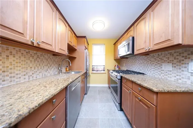 a kitchen with stainless steel appliances granite countertop a sink and a stove