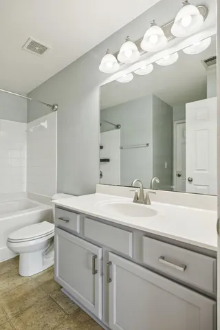 a bathroom with a sink a toilet and a large mirror