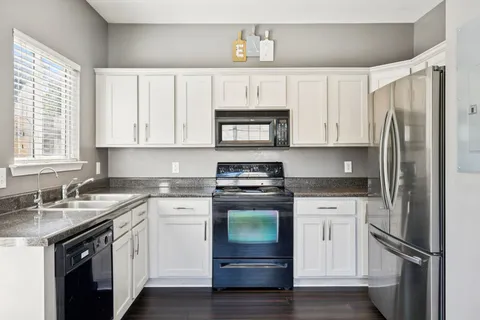 a kitchen with stainless steel appliances granite countertop a refrigerator sink and stove