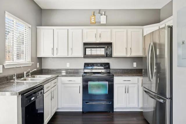 a kitchen with stainless steel appliances granite countertop a refrigerator sink and stove