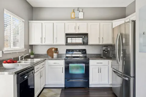 a kitchen with stainless steel appliances granite countertop a refrigerator sink and stove