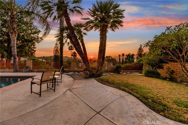 a row of palm trees and swimming pool in the backyard of a house