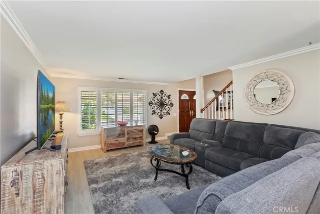 a living room with furniture a flat screen tv and a large window