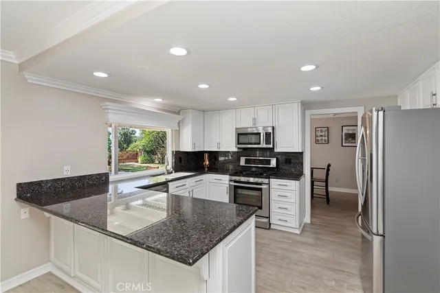 a kitchen with stainless steel appliances granite countertop a sink stove and refrigerator