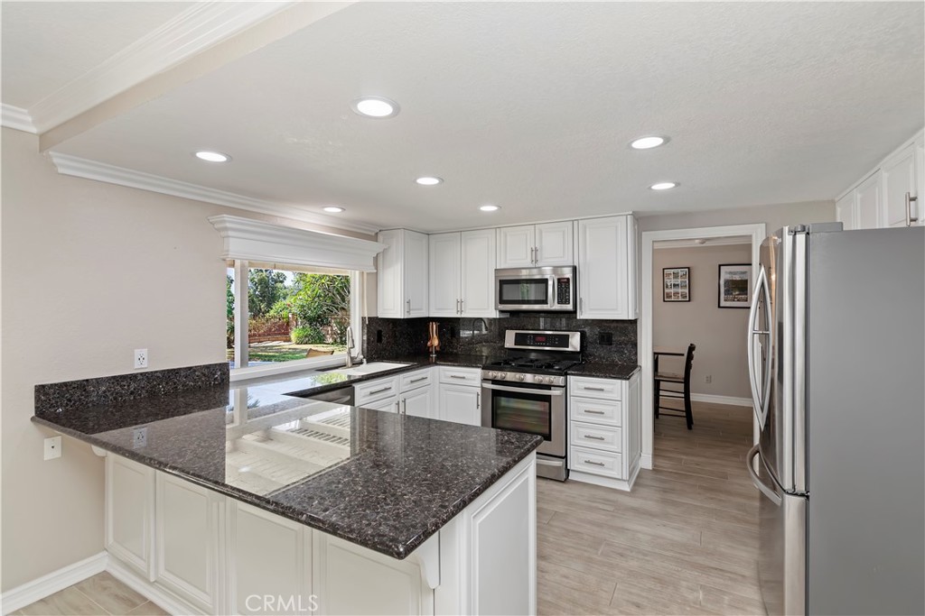 6225 Promontory Lane Riverside, CA 92506 - Photo 4 of 20 a kitchen with stainless steel appliances granite countertop a sink stove and refrigerator