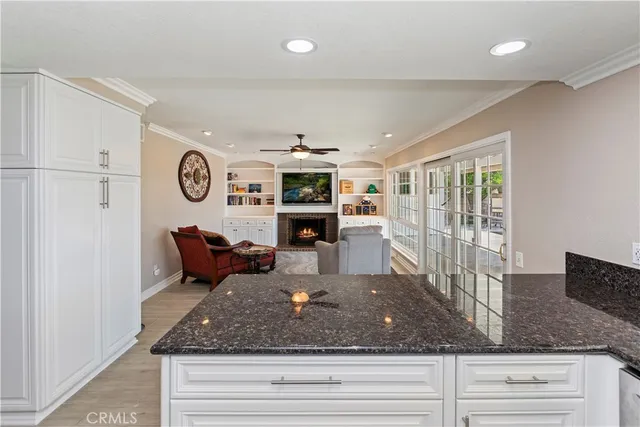 a kitchen with a refrigerator a stove top oven a clock and a window