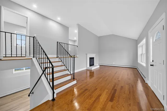 a view of a hallway with wooden floor and staircase
