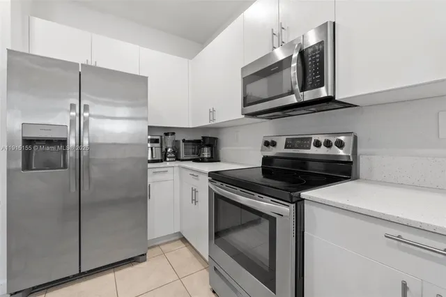 a kitchen with stainless steel appliances granite countertop a refrigerator stove and microwave