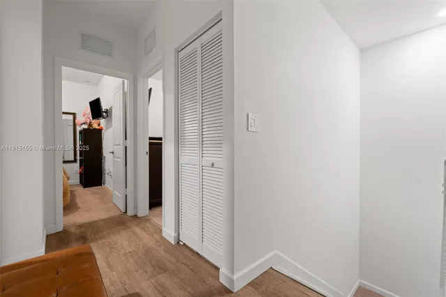 a view of a hallway with closet and front door