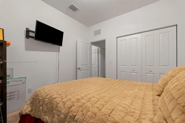 a bedroom with a bed and a flat screen tv