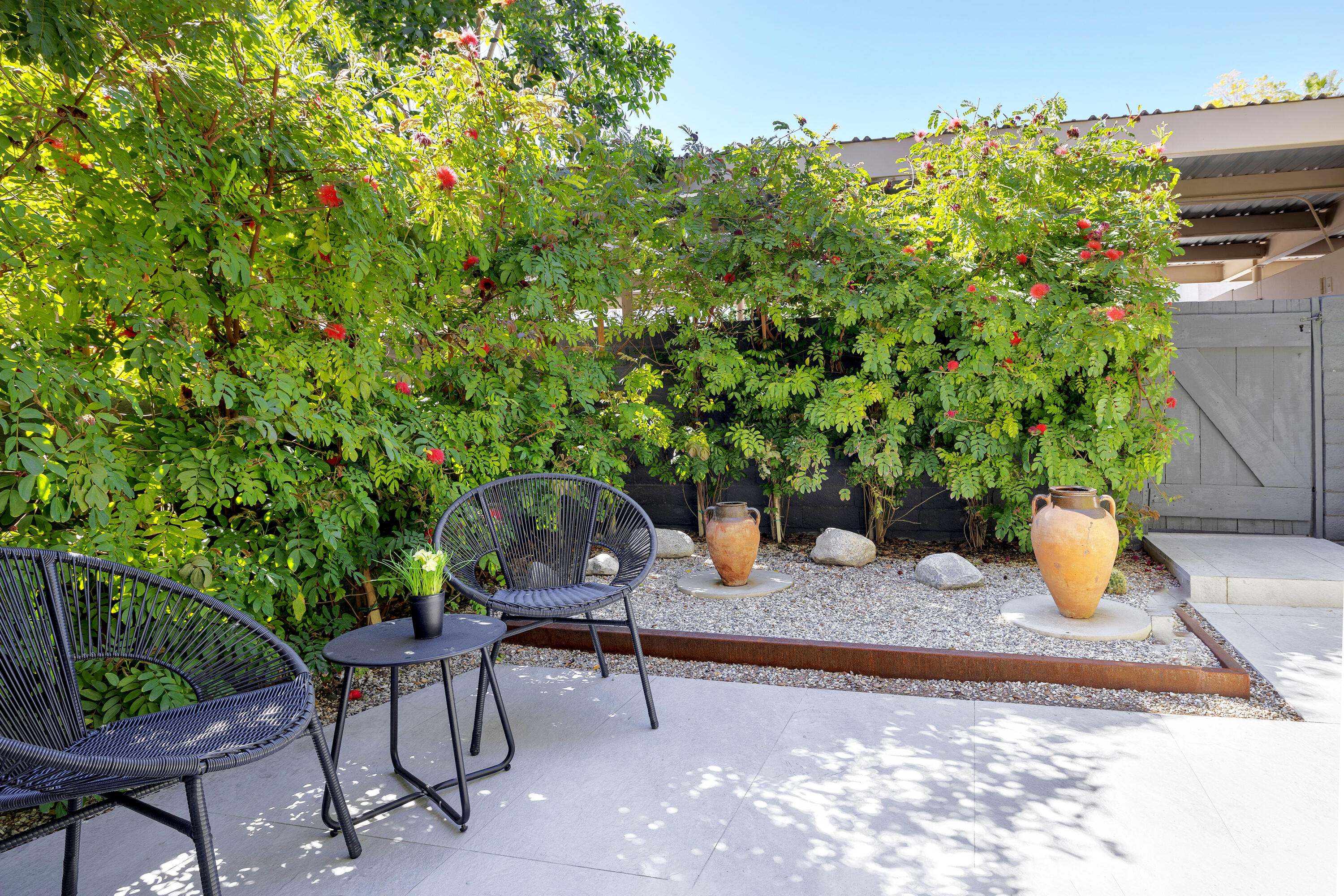 250 East Via Escuela, Unit G Palm Springs, CA 92262 - Photo 20 of 25 a backyard of a house with table and chairs