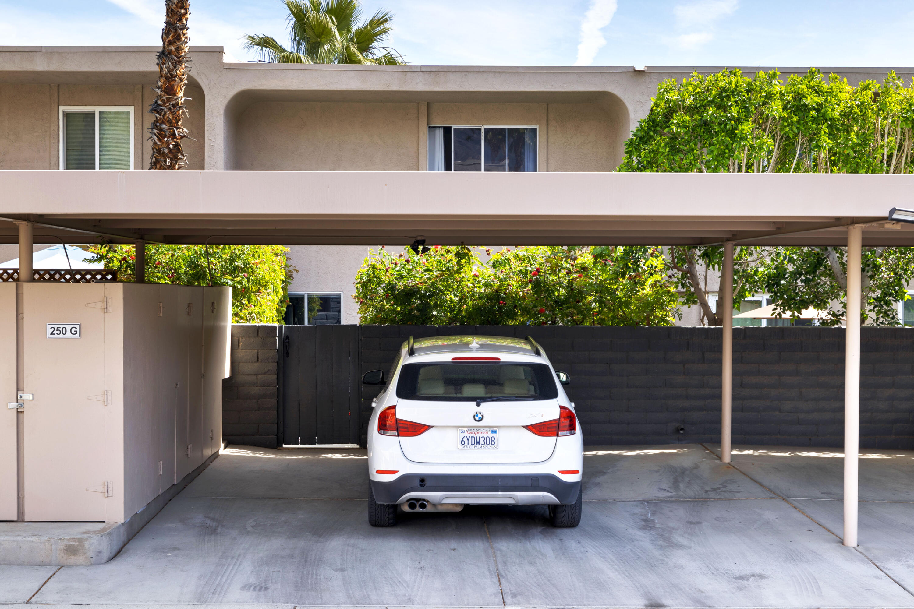 250 East Via Escuela, Unit G Palm Springs, CA 92262 - Photo 21 of 25 a car parked in front of a building