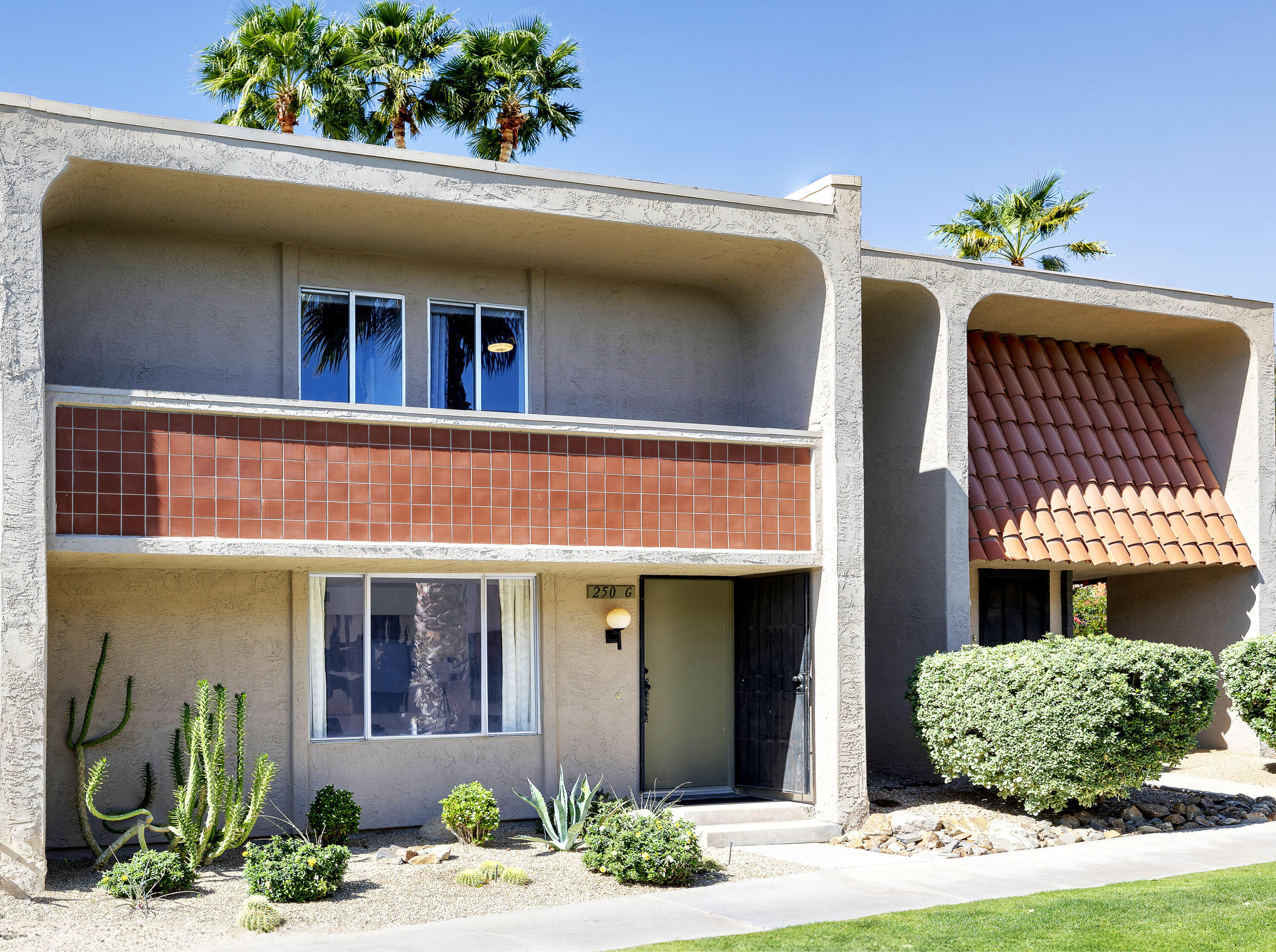 250 East Via Escuela, Unit G Palm Springs, CA 92262 - Photo 22 of 25 a front view of a house with a garden