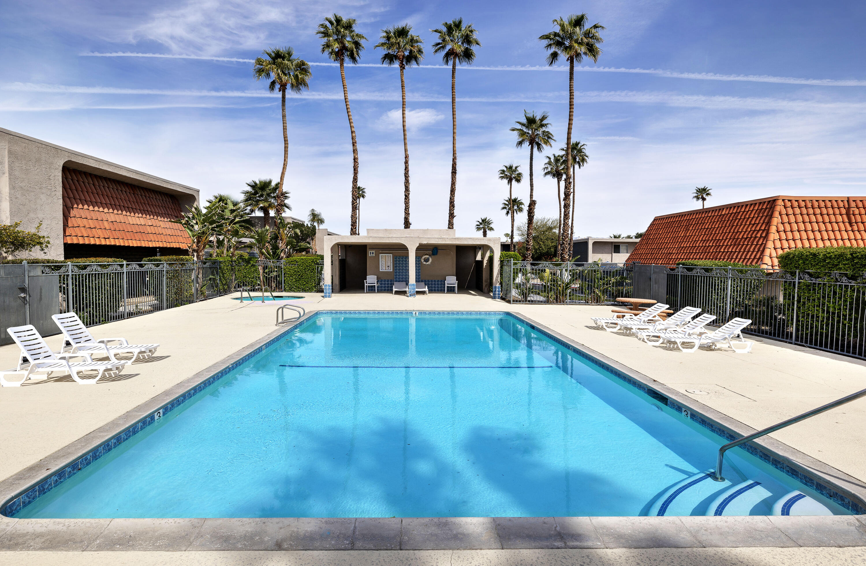 250 East Via Escuela, Unit G Palm Springs, CA 92262 - Photo 24 of 25 a view of a swimming pool with a lounge chairs