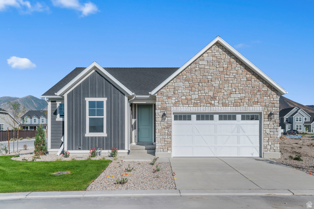 Contemporary ranch-style residence featuring a stone facade and vertical siding accents