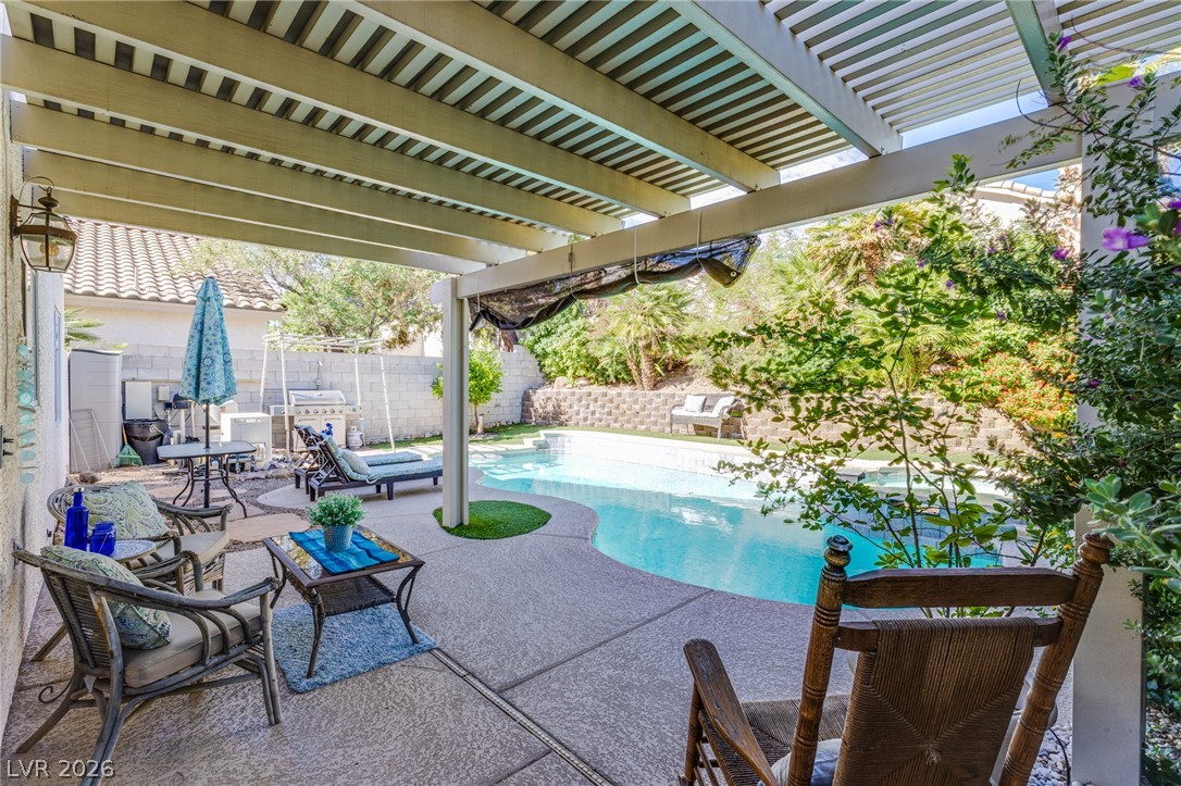 253 Camelback Ridge Avenue Henderson, NV 89012 - Photo 3 of 26 A spacious covered patio overlooks a private sparkling swimming pool and surrounding garden walls.