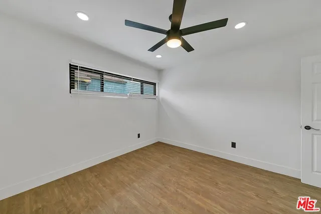 an empty room with a ceiling fan and window