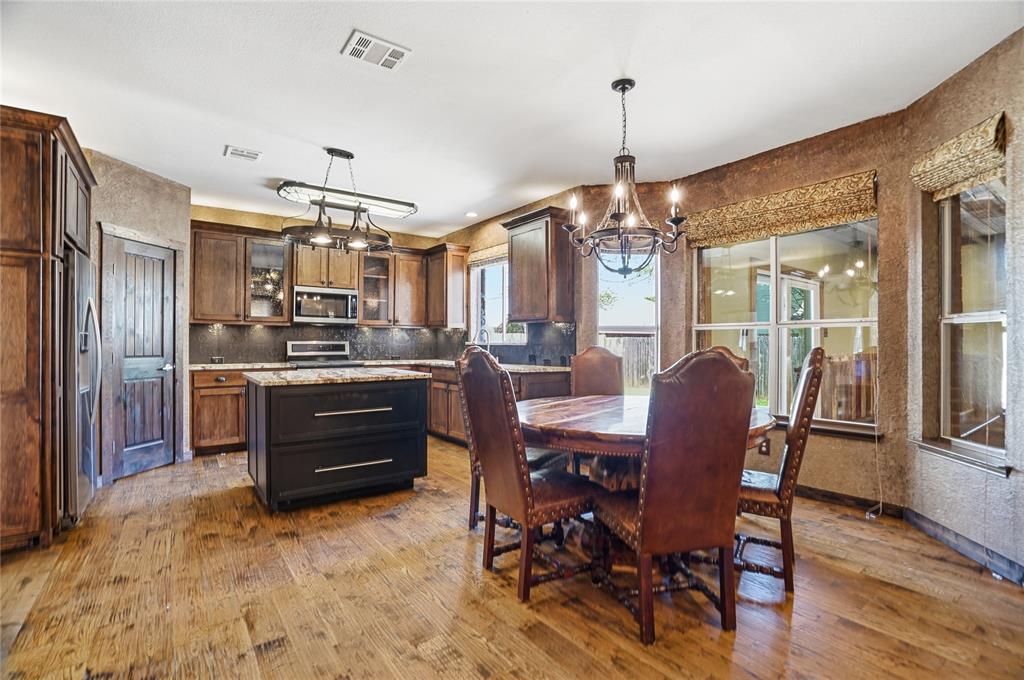 2133 Rustic Ridge Drive Keller, TX 76248 - Photo 11 of 40 Dining space featuring a chandelier and dark wood finished floors