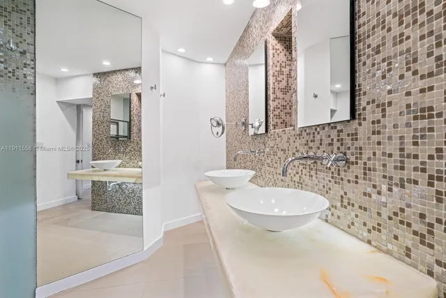 a bathroom with a granite countertop sink a toilet a mirror and bathtub