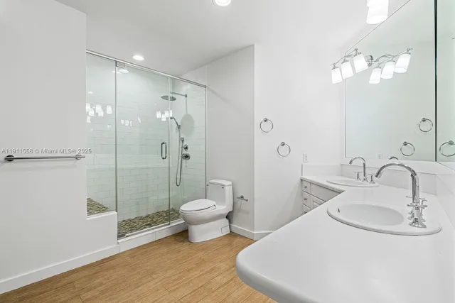 a bathroom with a sink a toilet and shower