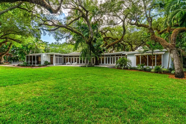 a view of house with a backyard