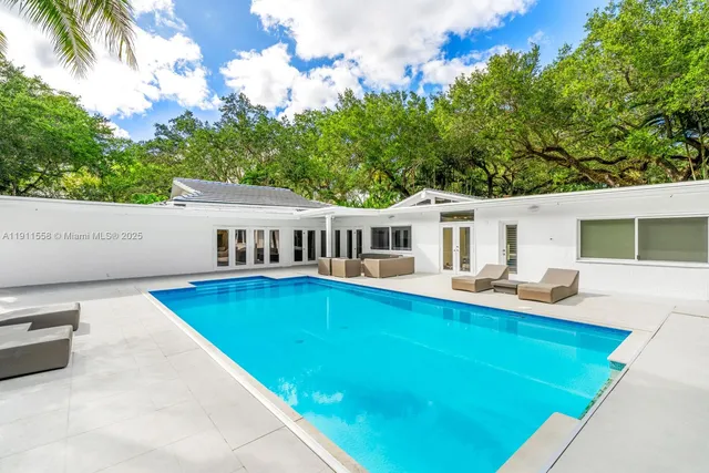 a view of a house with pool and a yard