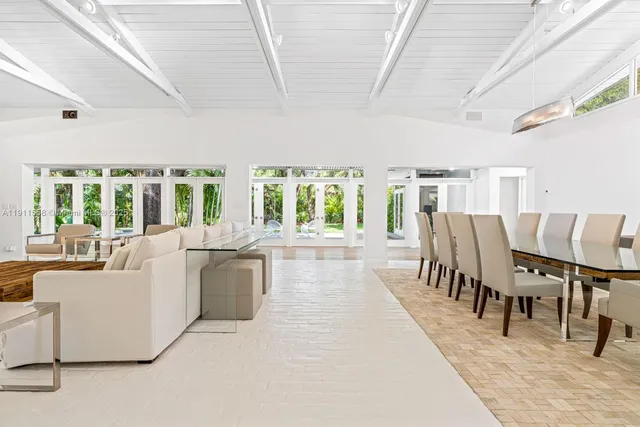 a dining room with furniture and a large window