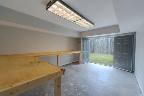 a view of an empty room with a fireplace and a window