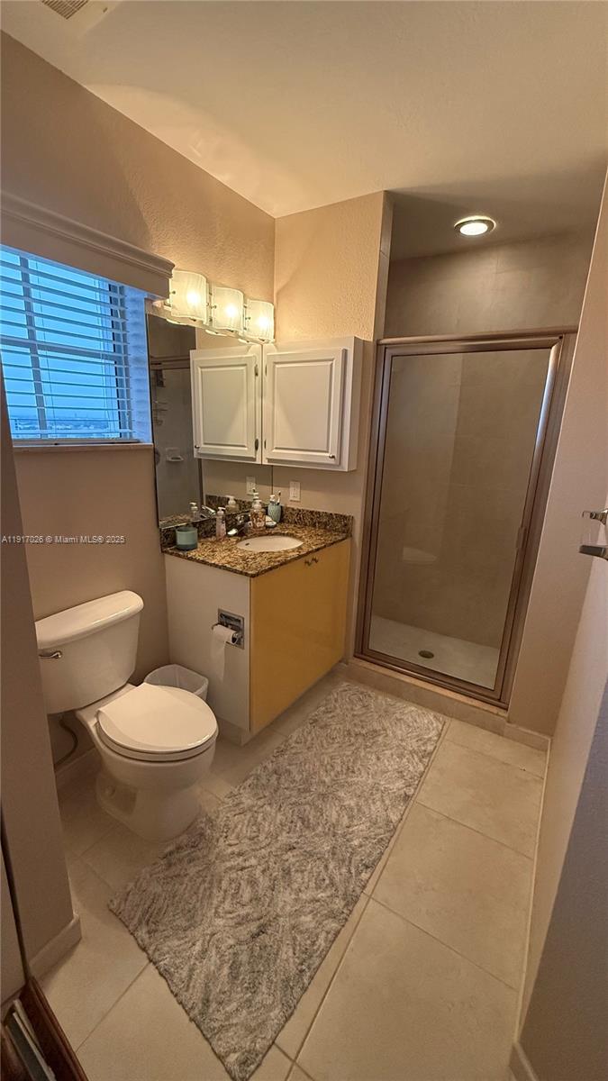 1830 Radius Drive, Unit 1105 Hollywood, FL 33020 - Photo 25 of 32 a bathroom with a granite countertop toilet and a sink