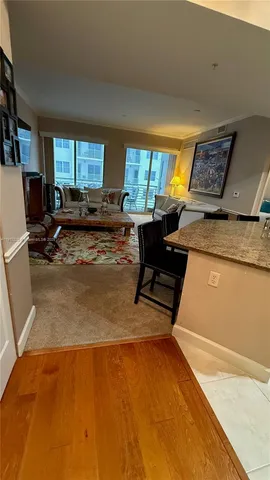 a living room with furniture and a open kitchen view
