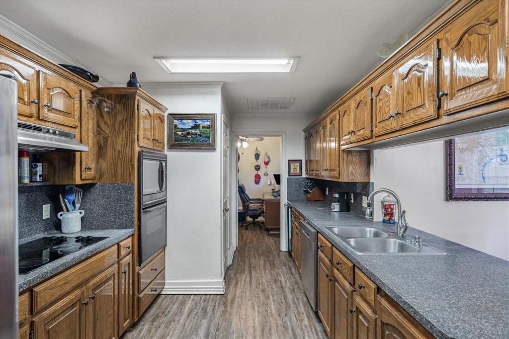 163 Granada Square Canton, TX 75103 - Photo 11 of 35 a kitchen with stainless steel appliances granite countertop lots of counter top space and wooden floor