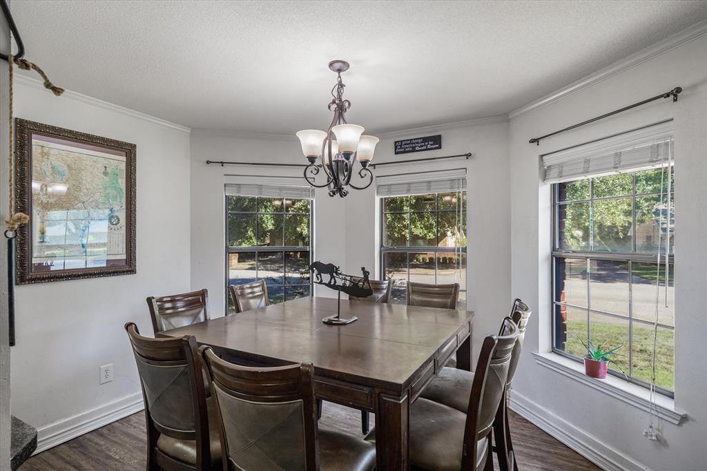 163 Granada Square Canton, TX 75103 - Photo 13 of 35 a dining room with wooden floor a chandelier a wooden table and chairs