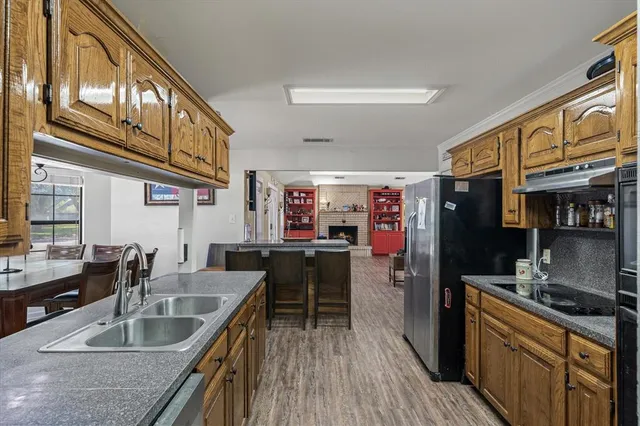 a kitchen filled counter top space a sink a stove and a wooden floors