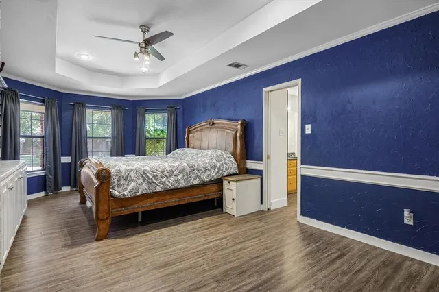 a bedroom with a large bed and a chandelier