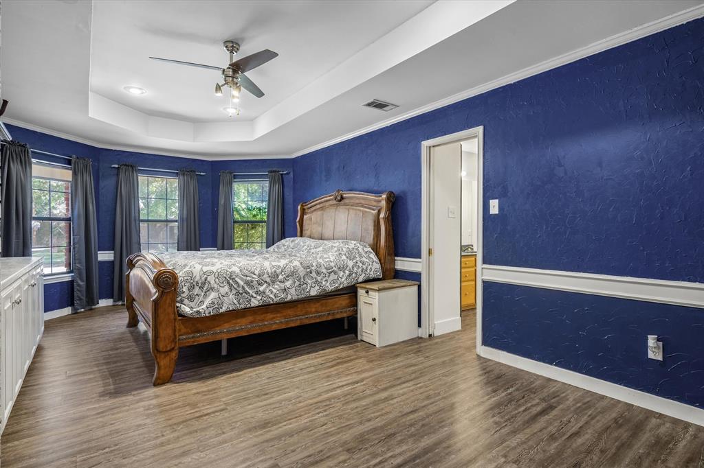 163 Granada Square Canton, TX 75103 - Photo 21 of 35 a bedroom with a large bed and a chandelier