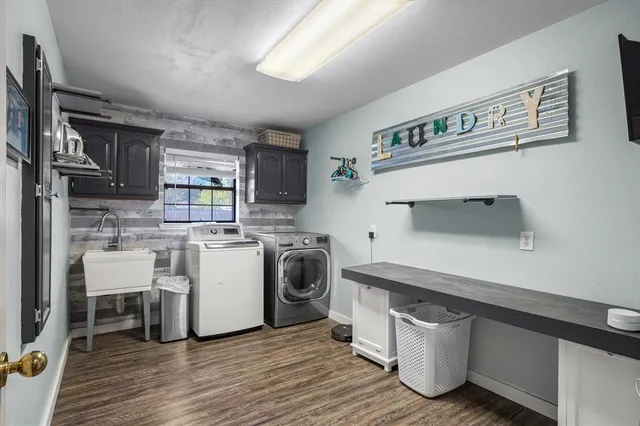 a kitchen with a sink cabinets and wooden floor