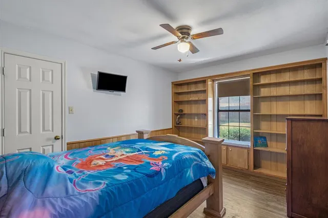 a bedroom with a bed a dresser and a book shelf