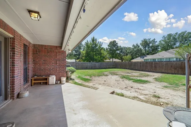 a backyard of a house with table and chairs