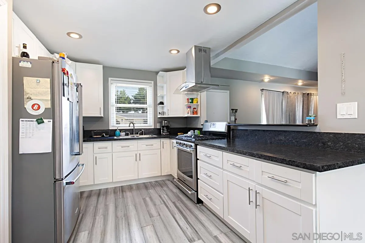 612 Broadview Street Spring Valley, CA 91977 - Photo 2 of 15 a kitchen with stainless steel appliances a refrigerator sink and white cabinets