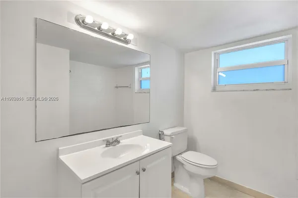 a bathroom with a sink a toilet and mirror